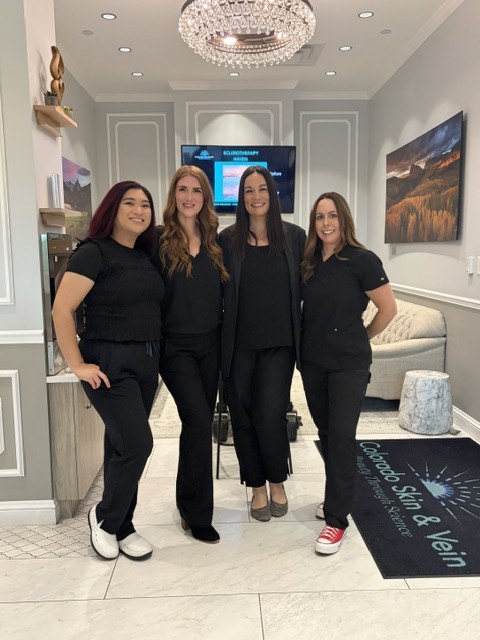 Four Colorado Skin & Vein team members standing in the practice's front lobby